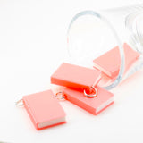 Miniature 3D pink book charm, approximately 27×18 mm, with textured cover detail and an attached jump ring, displayed on a white background.