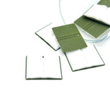 3D dark green open book charm with visible pages and gold detailing, displayed on a white background.