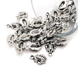 small silver frog charms on a white background