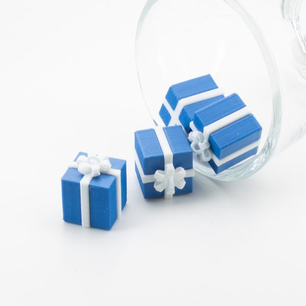 3D blue gift-box charm with ribbon and bow detailing, approximately 13×13 mm, shown on a white background.
