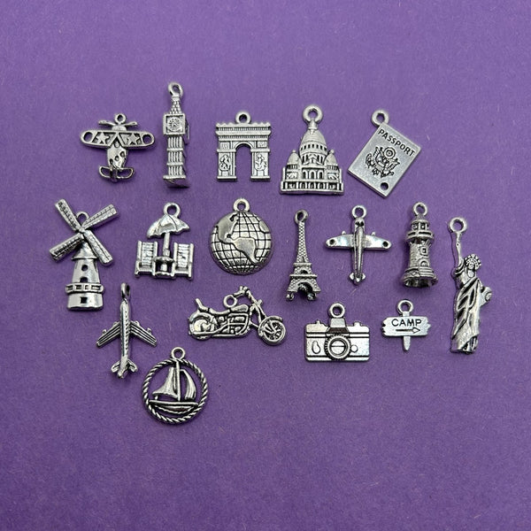 A collection of 17 mixed silver-toned travel-themed charms in various sizes and shapes, displayed together.