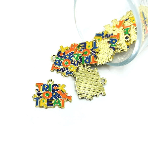 Gold-tone charm with “TRICK OR TREAT” text, displayed against a white background.
