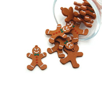 A gingerbread man-shaped charm, approximately 20×28 mm, with a loop for attachment, shown on a white background.