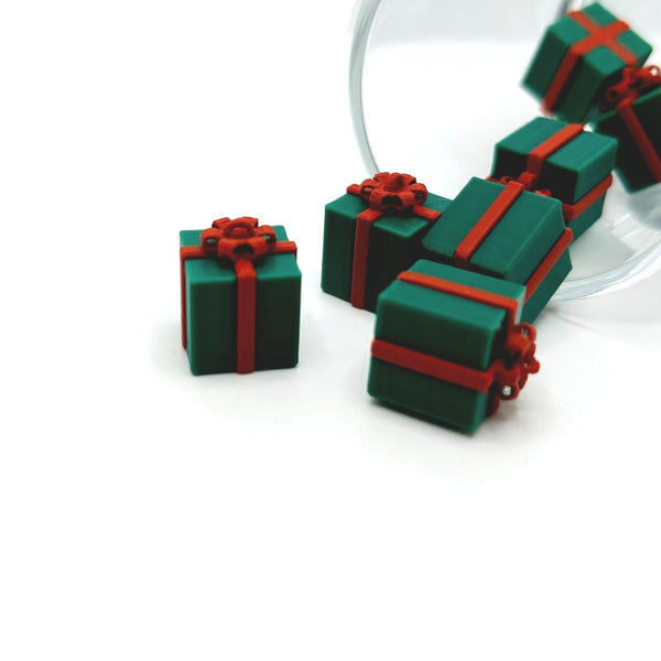 3D green gift box charm with ribbon and bow detailing, measuring approximately 13×13 mm, displayed on a white background.