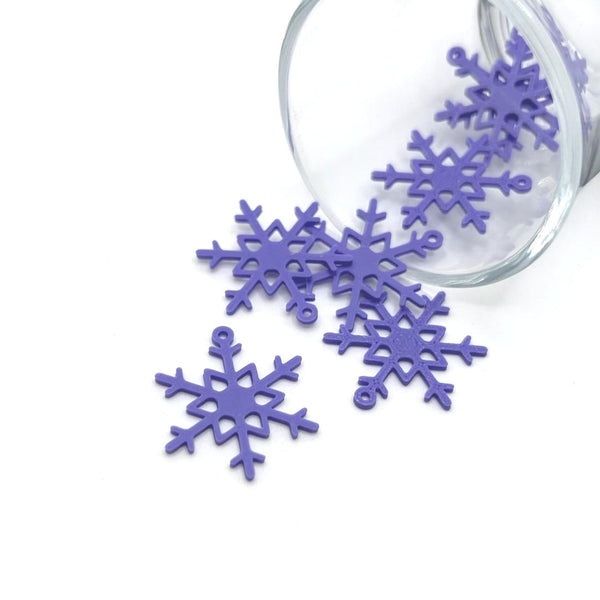 Purple enamel snowflake charm with intricate cut-out design, approximately 22×26 mm, displayed on a white background.