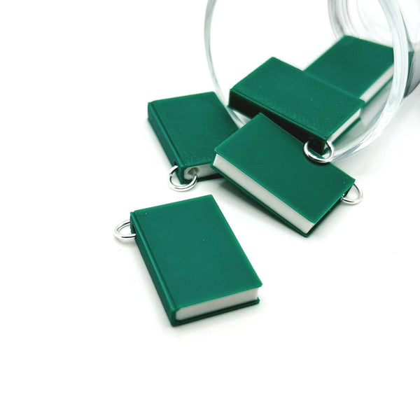 A small 3D book charm in  bright green color, approximately 27×18 mm, with a textured cover surface and an attached jump ring for hanging, shown on a white background.