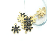 Gold and black snowflake-shaped charms on a white background