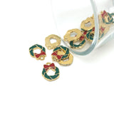 Gold and green wreath-shaped charms with red centers on a white background
