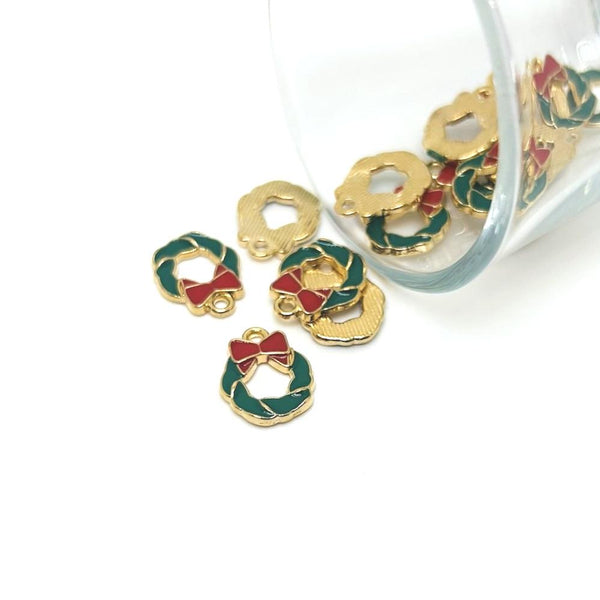 Gold and green wreath-shaped charms with red centers on a white background