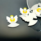 White angel figurines with yellow halos on a black surface