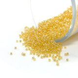 Small orange beads spilling out of a container on a white background