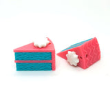 Two pink and blue miniature cake charms on a white background