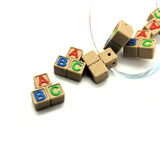 Wooden blocks charms with colorful letters on a white background