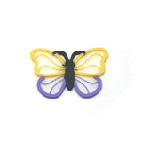 Butterfly-shaped hair charm with yellow, purple, and black colors on a white background
