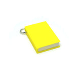 Yellow book-shaped charm on a white background