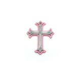 pink and silver ornate cross charm on a white background
