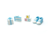 Set of babyboy themed items including shoes, blocks, cake, and gift on a white background