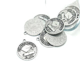 Silver graduation-themed pendants on a white background