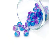 8 mm crackle glass beads in blue and purple hues on a string, sparkling with textured facets—great for jewelry-making and craft creations.