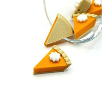 3D pumpkin pie charm with orange filling, golden crust, and whipped topping, shown on a white background.