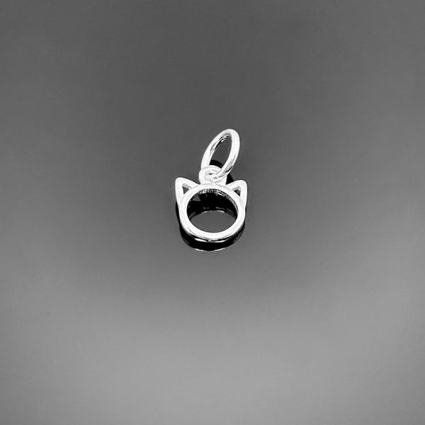 A tiny sterling silver cat charm, approximately 8 × 7 mm, with stylized cat silhouette and top loop, displayed on a clean black background.