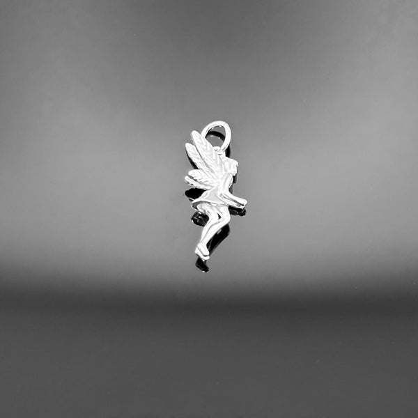 A sterling silver fairy charm measuring approximately 28×10 mm, featuring delicate wings and a hanging loop, displayed on a black background.