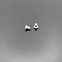 A collection of tiny sterling silver butterfly-style earring backs (ear nuts), approximately 3×3 mm each, displayed on a clean black background.