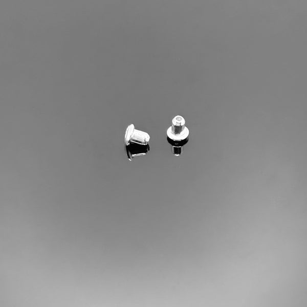 A collection of tiny sterling silver butterfly-style earring backs (ear nuts), approximately 3×3 mm each, displayed on a clean black background.