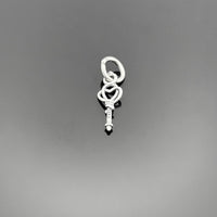 A 14×5 mm sterling silver key charm with an aged, oxidized finish, showcasing detailed grooves and a small top loop, displayed on a black background.