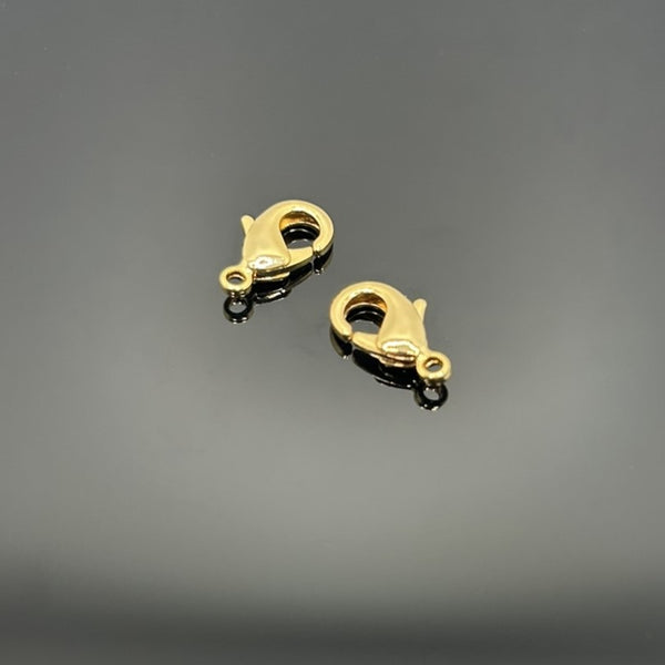 A collection of small gold-tone lobster clasp clasps measuring approximately 12 × 7 mm displayed on a black background.
