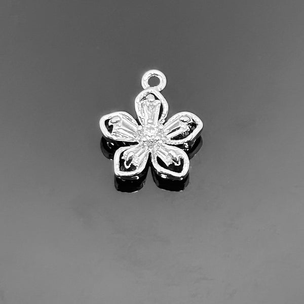 A 10×9 mm platinum-colored flower charm meticulously encrusted with micro pave cubic zirconia stones, displayed on a black background.