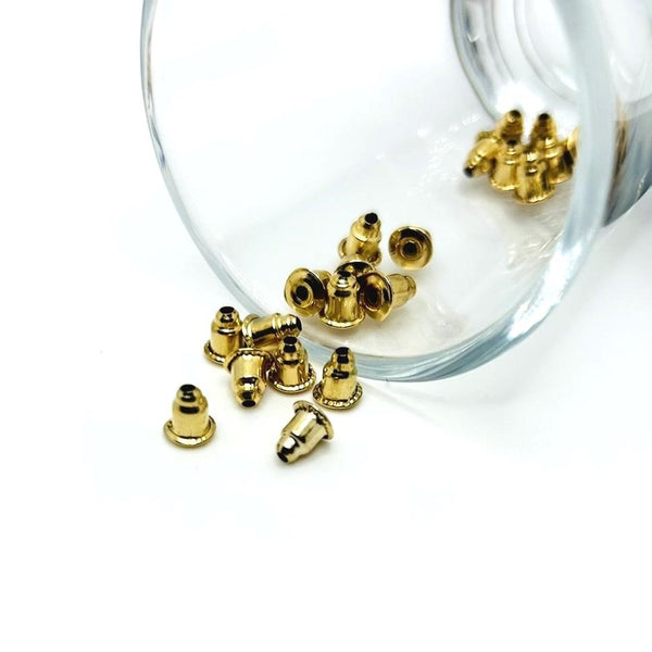 A bundle of KC gold-plated iron bullet-style earring backs (6 × 5 mm) with stabilizing discs, displayed on a neutral background.