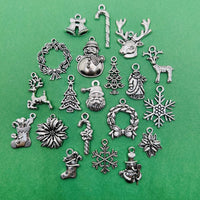 A collection of silver-toned Christmas charms—60 pieces total, featuring 20 unique designs.