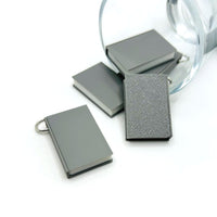 A small 3D gray book charm, approximately 27×18 mm, with detailed cover texture and an attached jump ring—shown against a clean white background.
