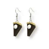 Pair of dangle earrings featuring miniature chocolate pie slice charms with whipped cream topping, attached to 20 × 18 mm ear wires, displayed on a white background.